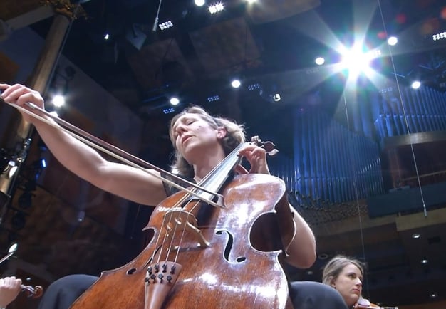 Kvinna som spelar cello. Fotografi.