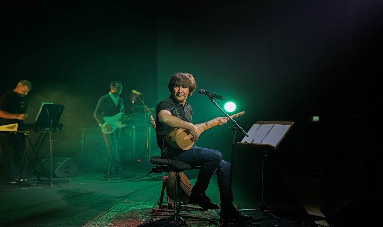 Man som spelar gitarr. Fotografi.