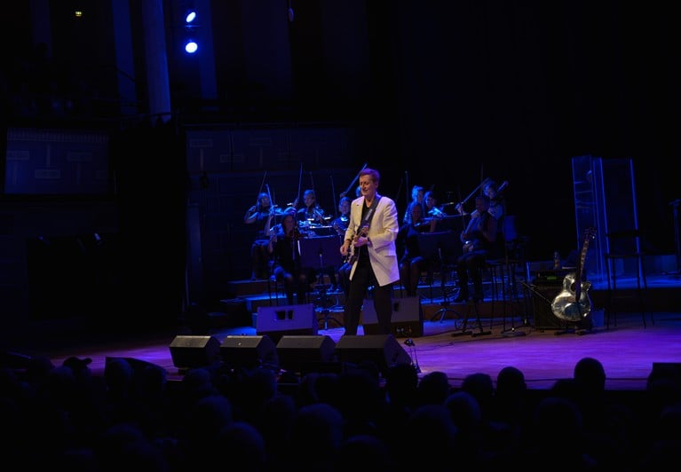 Man som spelar gitarr. Fotografi.