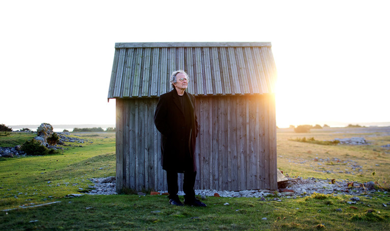 Man vid hus. Fotografi